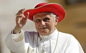 Pope Benedict XVI wears a red hat as he arrives to lead his weekly general audience in Saint Peter's Square at the  Vatican