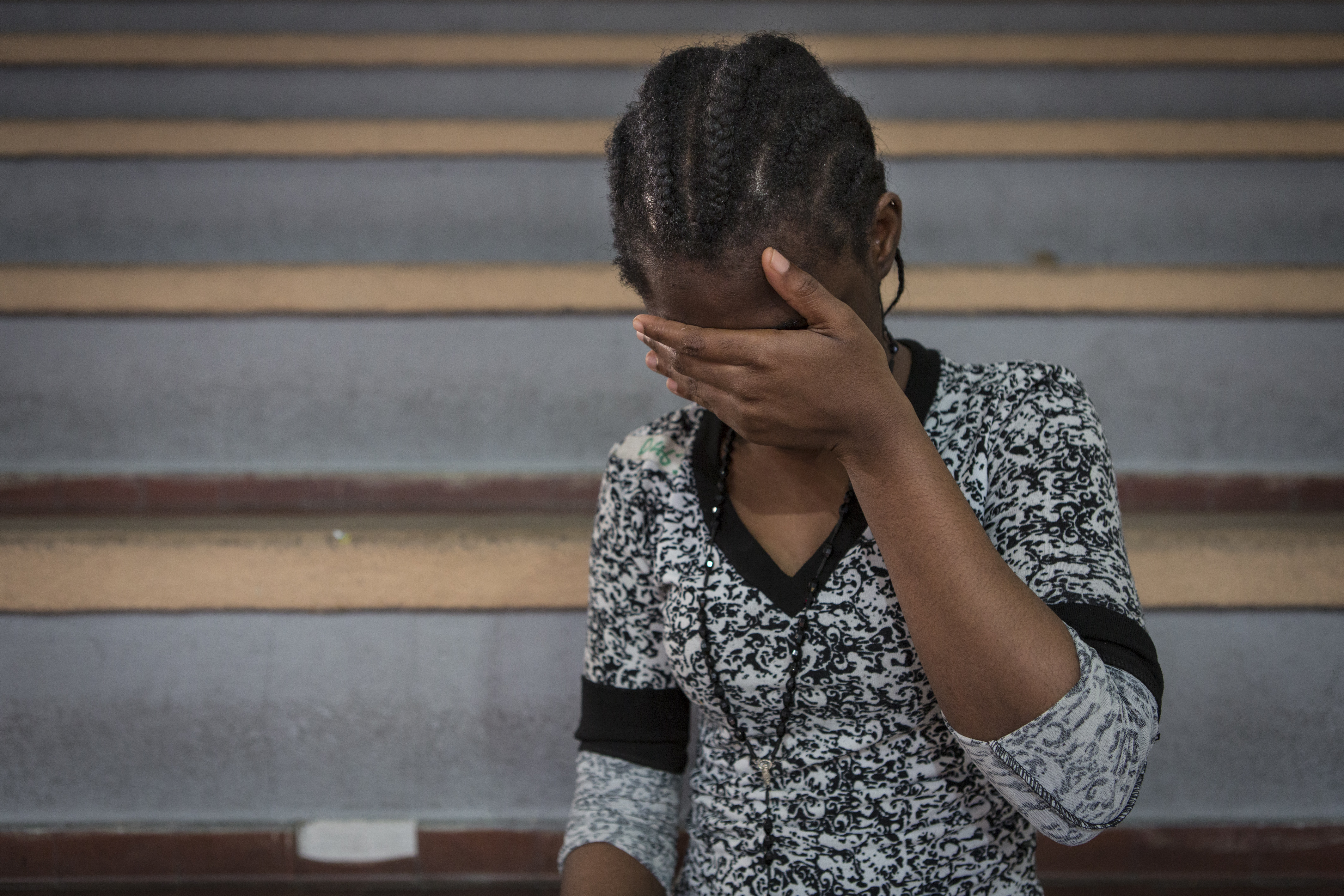 Una ragazza nigeriana, di 17 anni, aspetta in un centro sportivo di Catania dove è stata accolta dopo l'arrivo in Italia (Foto Save The Children)