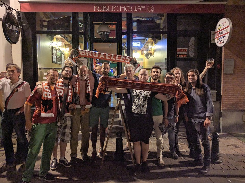 Tifosi della Roma davanti al The Public House. Sulla sinistra un supporter genoano.