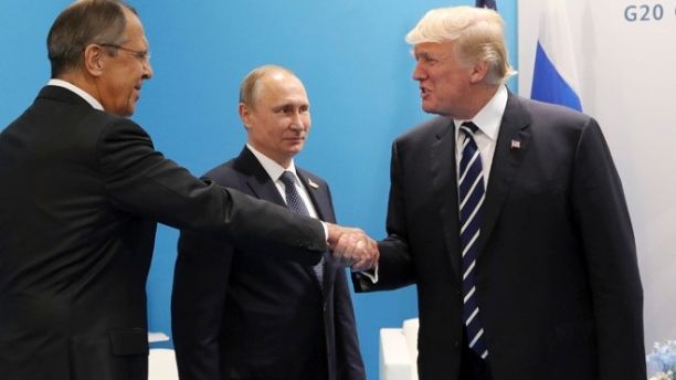 Il presidente degli Stati Uniti, Donald Trump (destra), stringe la mano al ministro degli Esteri russo, Sergei Lavrov. Al centro Vladimir Putin, presidente russo.