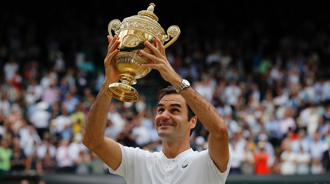 Roger Federer solleva il trofeo messo in palio dal torneo di Wimbledon. E' il suo ottavo e storico successo.