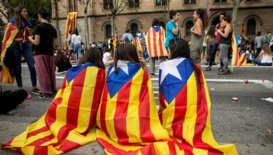 Alcuni manifestanti indipendentisti con la bandiera catalana sulle spalle