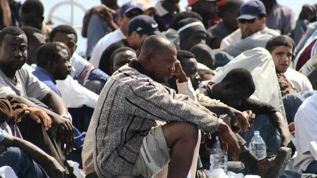 migranti in attesa di essere identificati