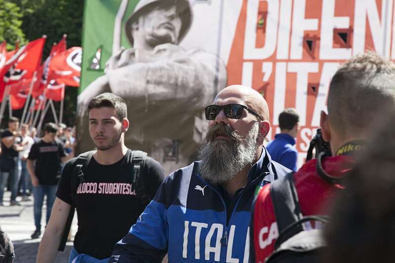 Gianluca Iannone, presidente di Casa Pound. Alle sue spalle uno striscione con l'immagine di Benito Mussolini