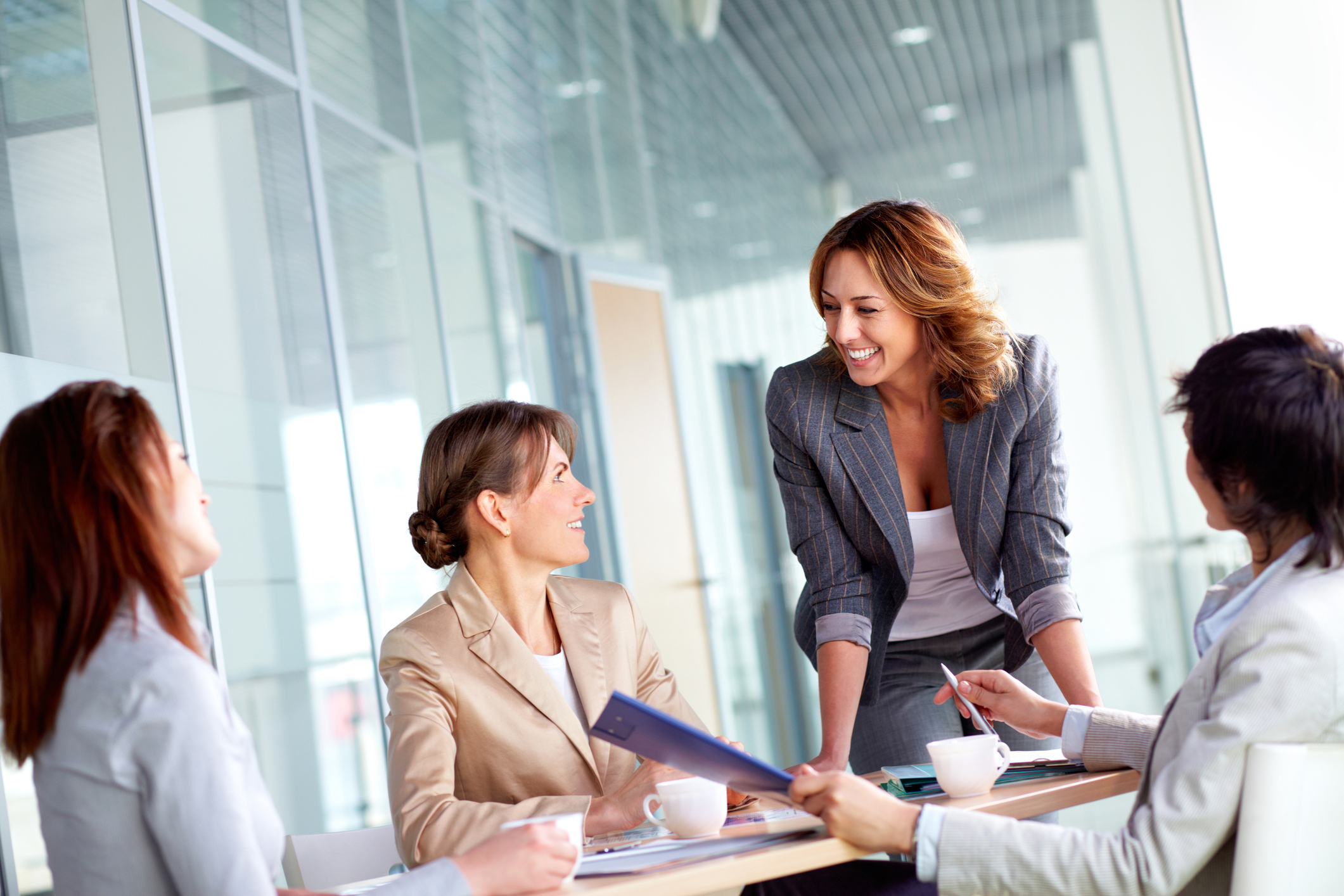 Image of four successful businesswomen interacting at meeting