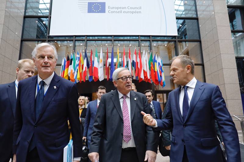 Michel Barnier, Jean-Claude Juncker e Donald Tusk vanno verso la conferenza stampa finale del Consiglio europeo.