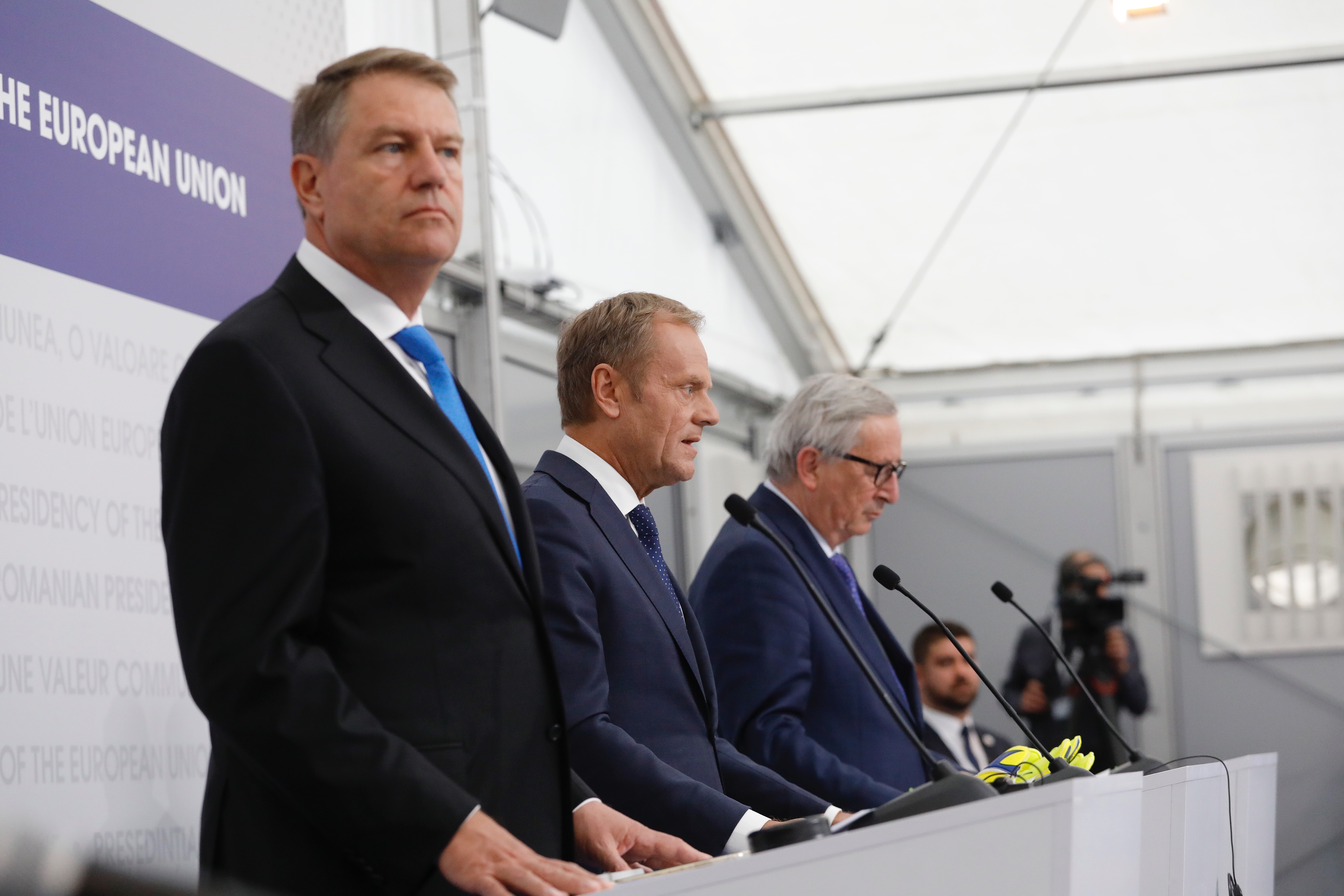 Il presidente del Consiglio europeo, Donald Tusk, tra il presidente romeno Klaus Iohannis (primo piano) e il presidente della Commissione europea, Jean-Claude Juncker, nella conferenza stampa finale del summit di Sibiu [foto: Consiglio europeo]