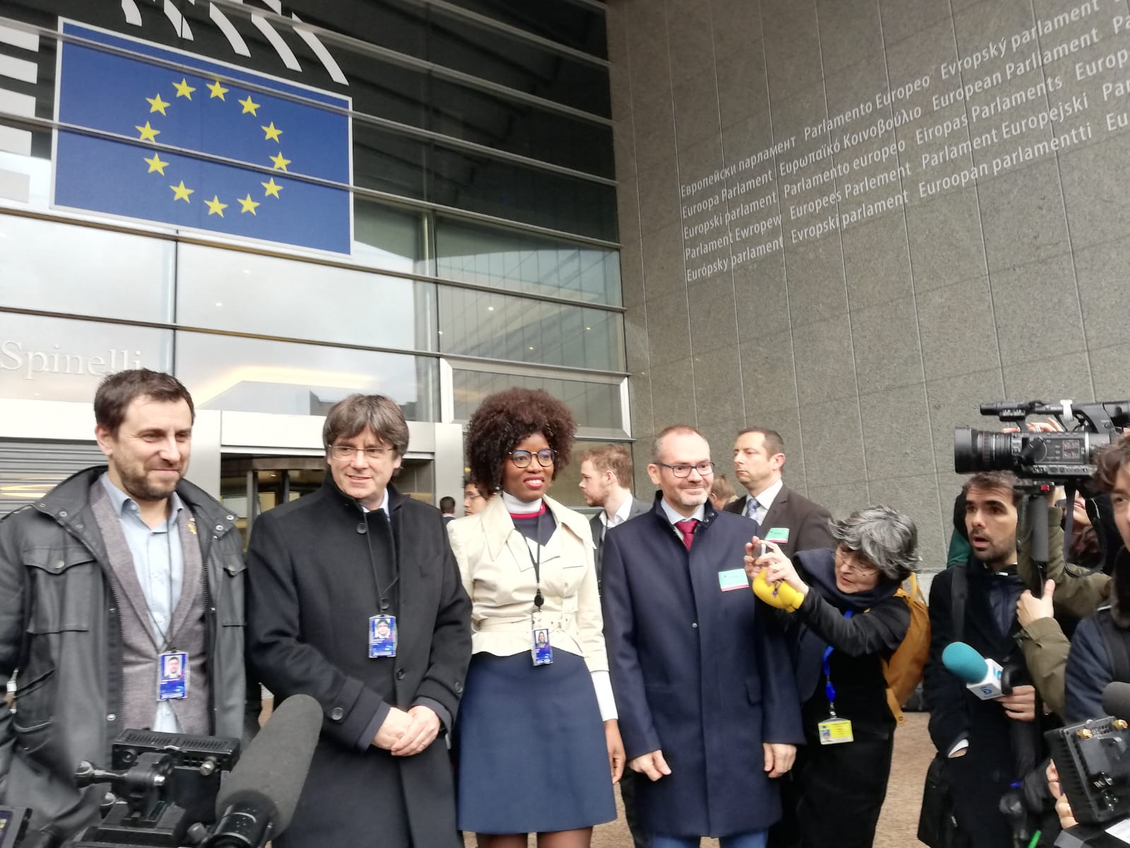 Toni Comin e Carles Puigdemont davanti al Parlamento europeo con il tesserino da deputati. Accanto a loro la deputata indipendentista fiamminga dell'NVA Assita Kanko