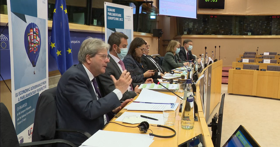 Il commissario per l'Economia, Paolo Gentiloni (primo piano) e il vicepresidente della Commissione UE, Valdis Dombrovskis (in fondo) a conferenza inter-parlamentare su coordinamento e governance economica. Le regole su deficit e debito non si rivedono [Bruxelles, 15 marzo 2022]