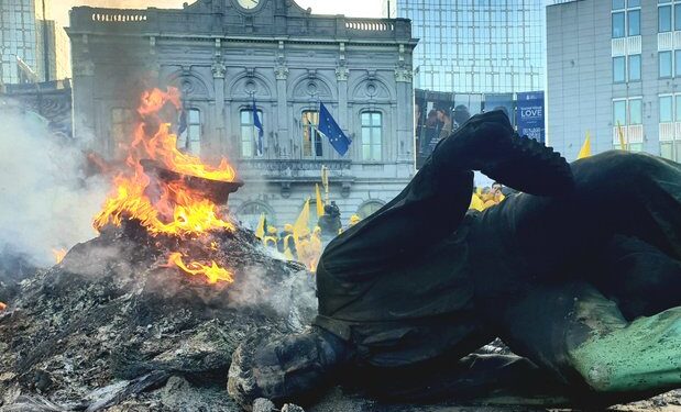 LA statua di un lavoratore della siderurgia abbattuta dai manifestanti a Bruxelles [Foto tratta da X @YvesRouyet]