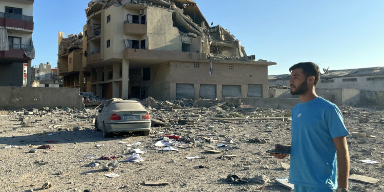 A man walks past destruction caused by Israeli airstrikes in the Masaken neighbourhood on the outskirts of Tyre on September 26, 2024 (Photo by Hassan FNEICH / AFP)