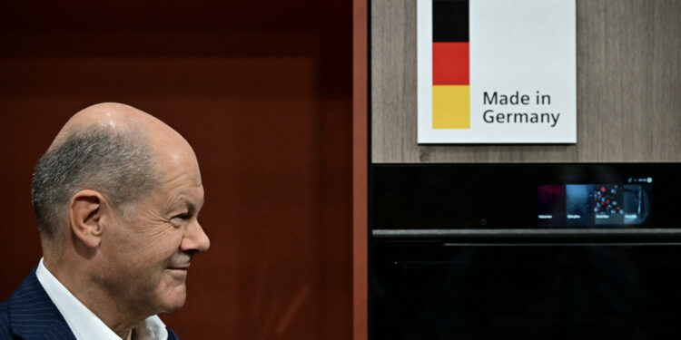 German Chancellor Olaf Scholz stands next to a sign reading "Made in Germany" at the booth of "Siemens" during his opening tour of the 100th edition of the "Internationale Funkausstellung" (IFA), the international trade show for consumer electronics and home appliances, on September 6, 2024 in Berlin. (Photo by Tobias SCHWARZ / AFP)