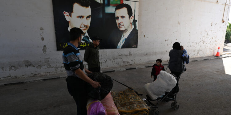 A family arrives in Syria's Jousieh border crossing after crossing from Lebanon on October 28, 2024. (Photo by LOUAI BESHARA / AFP)